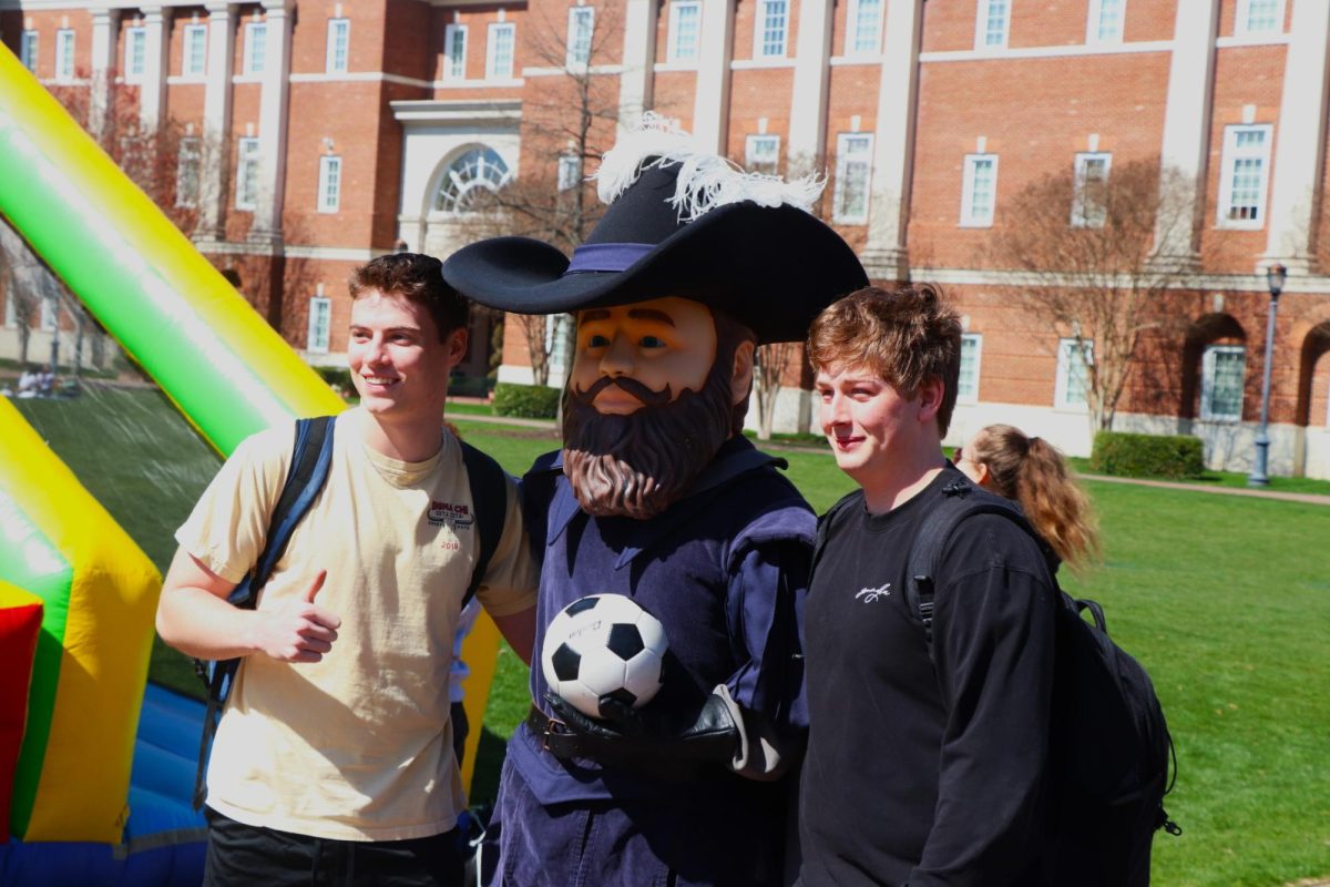 Captain Chris poses for a photo with two CNU students in front of the 3-in-1 sports inflatable
