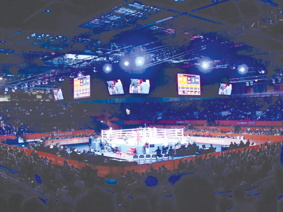An+olympic+boxing+match+taking+place+during+the+2012+London+Olympics.+Olympic+boxing%2C+Excel+Arena%2C+2012+by+Nick+is+licensed+under+the+CC+By+2.0+Deed.